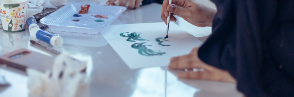 Händer som målar med pensel och färg