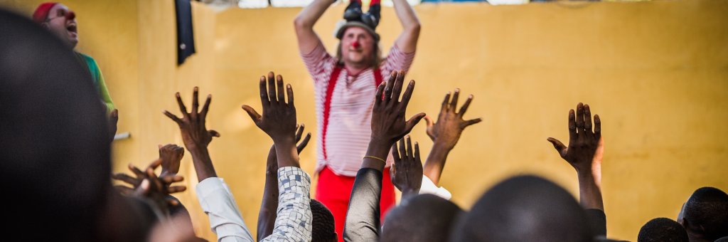 Clowner gör ett akrobatiskt nummer inför en hänförd publik