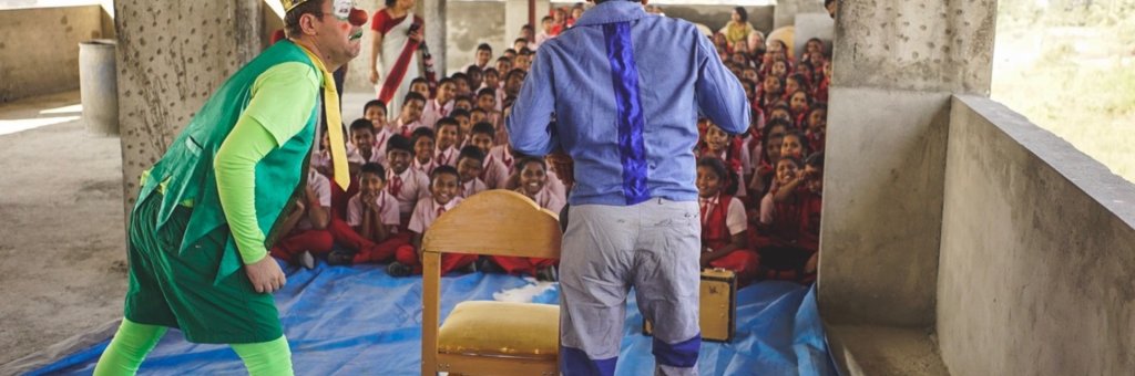 Clowner med en publik av barn framför sig