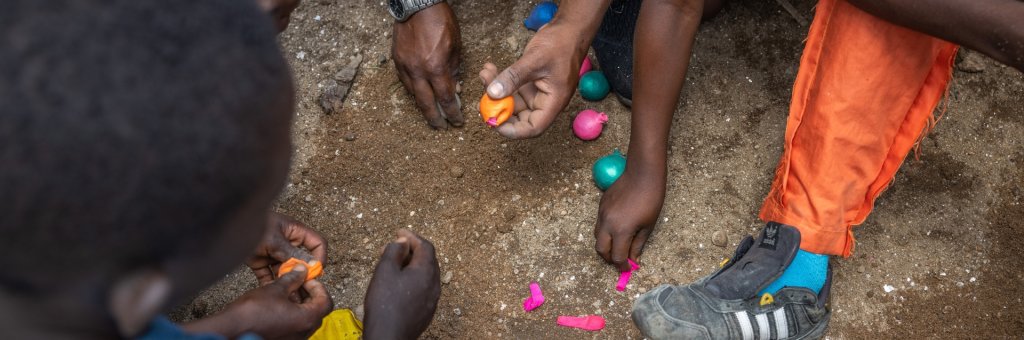 Händer som gör jongleringsbollar på jordig mark