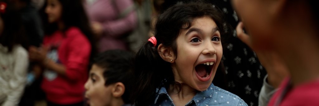 En flicka som ler och gapar stort