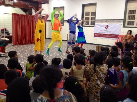 Clowner sjunger och dansar inför en publik av barn