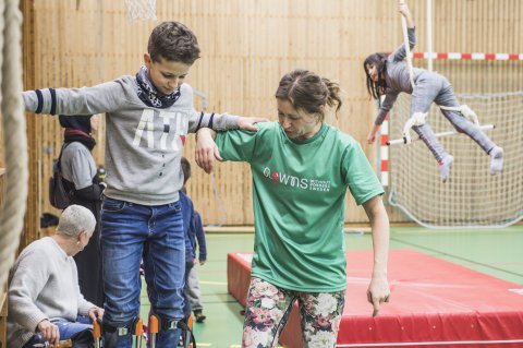 Ett barn går balansgång med en pedagogs hjälp