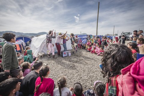 Artisterna står framför ett tält och dansar för publiken