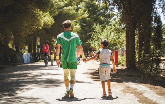 En artist och barn går hand i hand