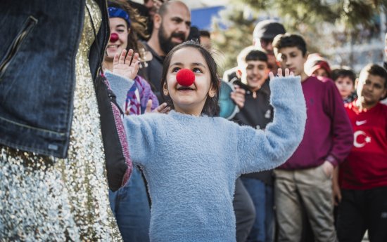 Ett skrattande barn med clownnäsa på