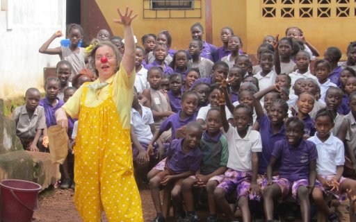Clown i gula kläder uppträder för en grupp barn