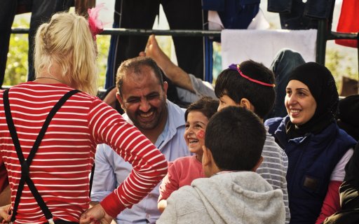 Clown med skrattande publik av både vuxna och barn