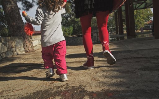 En clown går håller ett barn i handen