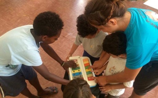 Vuxna och barn spelar på ett färgglatt barninstrument